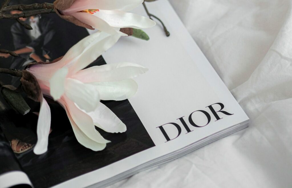 Lunettes à monture dorée posées sur une page blanche, évoquant la lecture du dictionnaire de style de Christian Dior