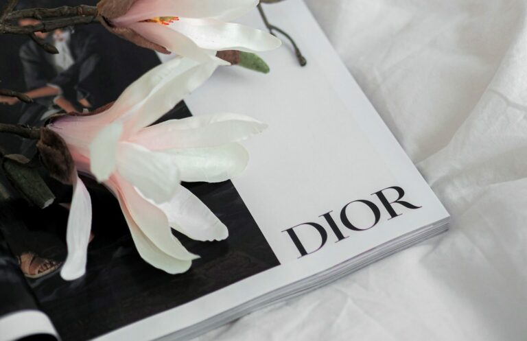 Lunettes à monture dorée posées sur une page blanche, évoquant la lecture du dictionnaire de style de Christian Dior
